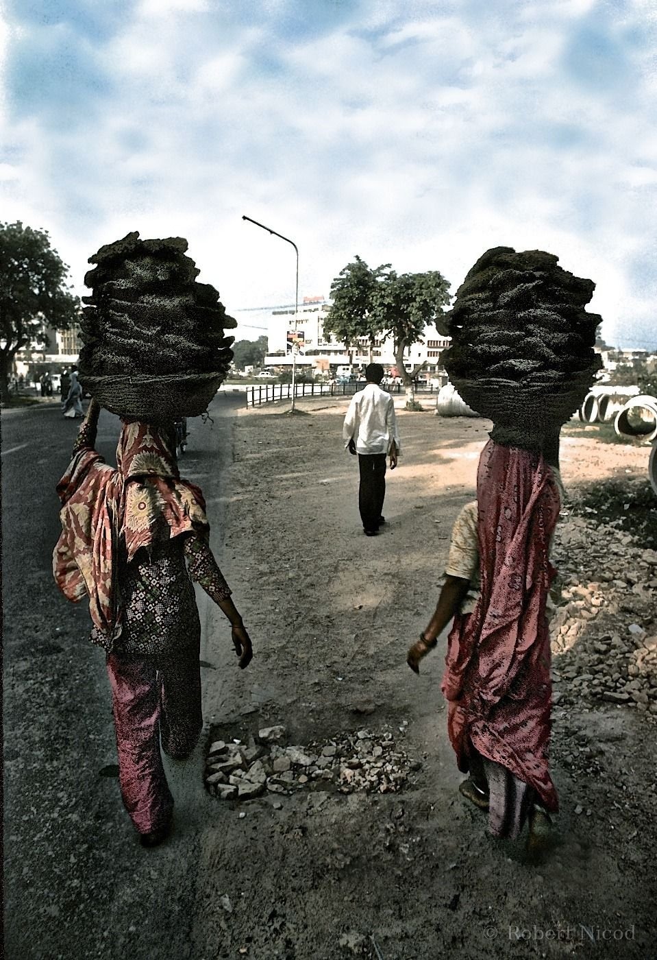 Reportage Inde 1977 — Femmes transportant des bouses de vache séchées, combustible du foyer, Delhi 1977